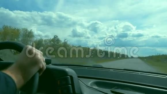 多云天气男子手在方向盘的汽车慢动作视频视频的预览图