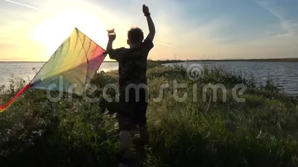 日落时放风筝的男孩慢动作剪影视频的预览图