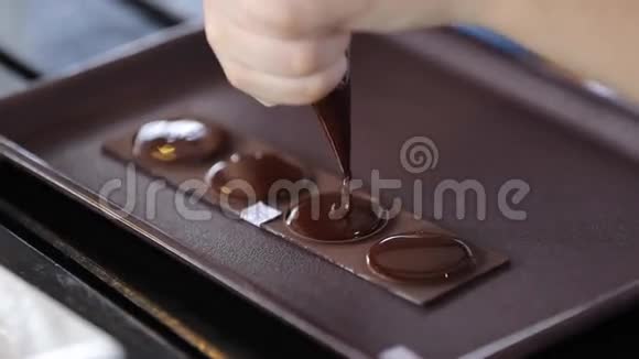 蛋糕装饰靠近糖果锅手挤压融化的巧克力做蛋糕的零件视频的预览图