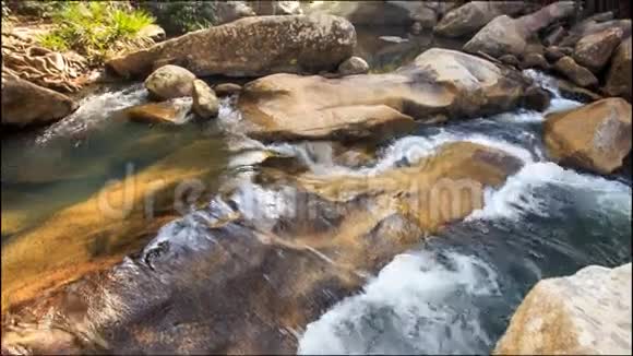 在公园的棕色岩石中流淌着小泡沫河视频的预览图
