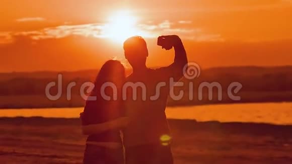 自拍拍摄一个女孩和男人在日落慢动作视频视频的预览图