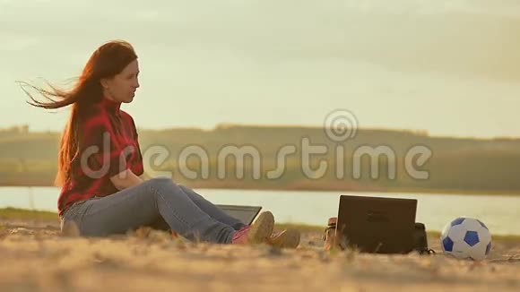 夜晚的沙滩女孩和男人手提电脑慢动作视频视频的预览图