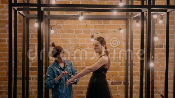 一位专业的化妆师穿着黑色婚纱做化妆模特在红砖的背景下视频的预览图