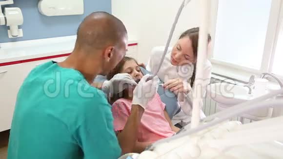 坐在牙科椅上给牙医和助理击掌的女孩视频的预览图