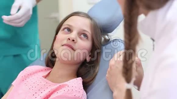 关闭男医生和女牙医检查一个小女孩视频的预览图