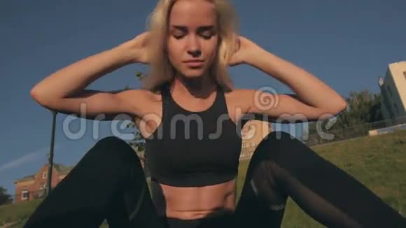 运动金发女孩模特在公园户外锻炼腹部锻炼视频的预览图