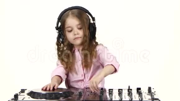 戴着耳机的小女孩为dj控制台演奏白色背景视频的预览图