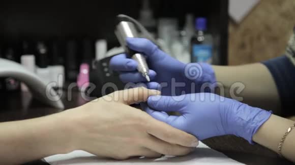 美甲师在美甲沙龙做美甲女人用指甲工具修指甲视频的预览图