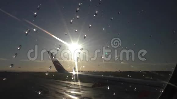 阳光照耀着飞机窗户上的雨滴视频的预览图
