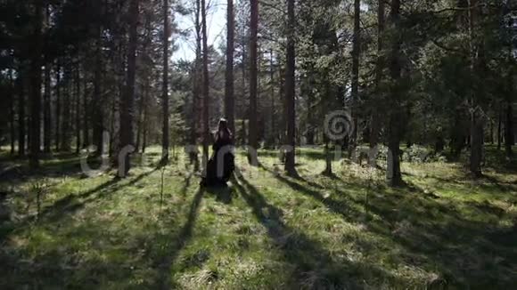 一个漂亮的女孩穿过树林慢动作视频的预览图