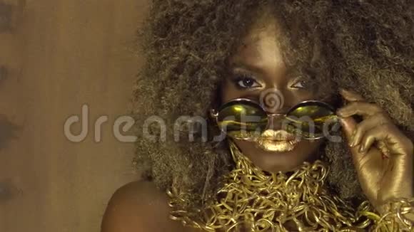 神奇的超现实金色非洲裔美国女模特戴着大墨镜妆容亮丽金光闪闪视频的预览图