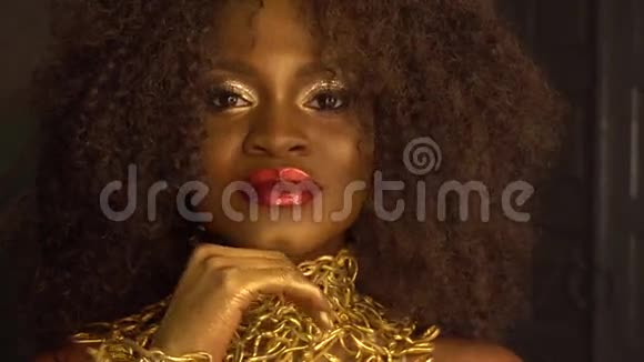 非洲裔美国女模特的超现实时尚肖像金色光面头饰创意概念黑工作室视频的预览图