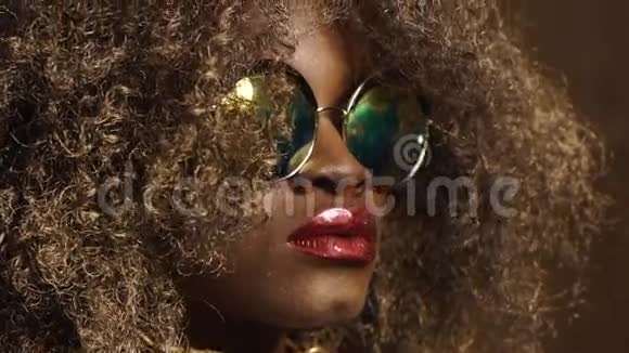 神奇的金色非裔美国女性模特戴着巨大的太阳镜亮晶晶的妆容光滑的金色视频的预览图