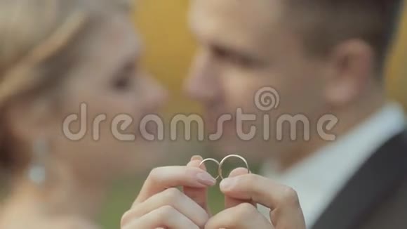 令人惊叹的新婚夫妇展示了他们结婚时的金戒指视频的预览图