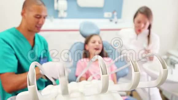 坐在牙科椅上给牙医和助理击掌的女孩视频的预览图