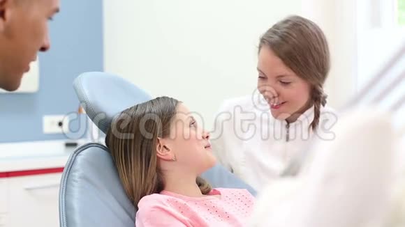 关闭女牙医和男外科医生检查一个小女孩的牙齿视频的预览图