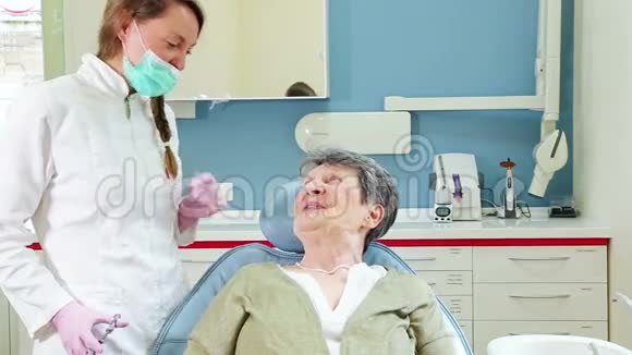 快乐的老年病人与牙医交谈视频的预览图