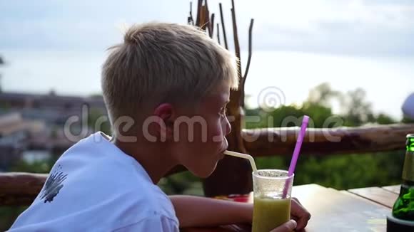 一个年轻人在咖啡馆的露台上喝鸡尾酒在户外视频的预览图