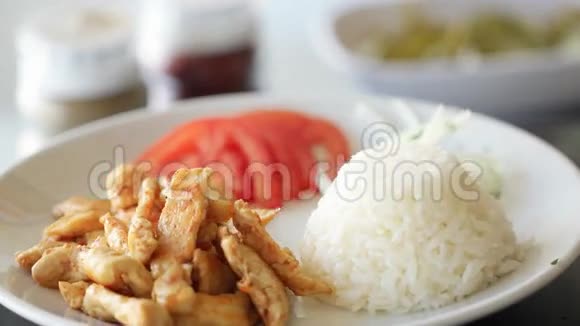 用米饭洋葱和西红柿在盘子上旋转的烤鸡视频的预览图