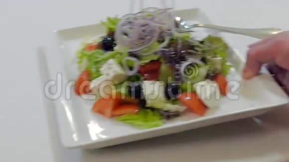 服务员在桌上放了一盘希腊沙拉视频的预览图