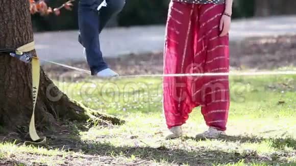 女人试图用绳子走路另一个人在保护她但镜头显示视频的预览图