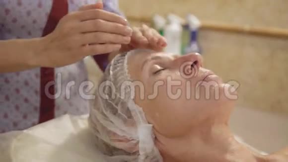 中年妇女在spa沙龙接受面颈部淋巴引流按摩视频的预览图