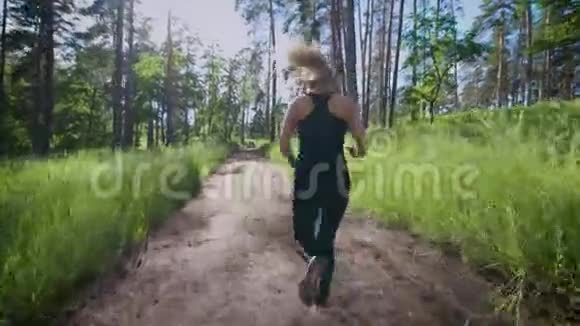 美丽的女人在森林的小径上奔跑视频的预览图