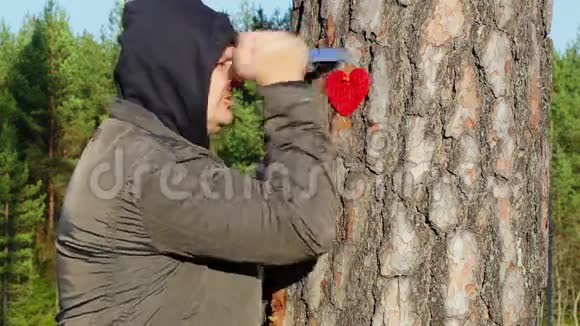 愤怒的男人拿着刀和布心靠近树视频的预览图