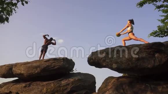 一对黑人健美运动员和一对白种人健美女士在岩石峰上一起做运动视频的预览图