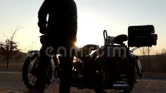 骑自行车坐在日落的摩托车上视频的预览图