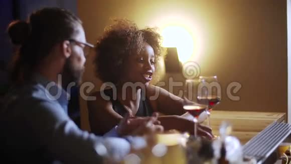 年轻人在豪华酒吧里和一个非常漂亮开朗的黑人女人调情他们聊天喝鸡尾酒视频的预览图