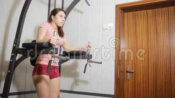 漂亮的女孩在健身房训练从事运动模拟器的女性视频的预览图
