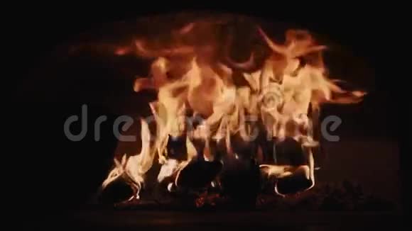 炽热的红色火焰燃烧黑暗房间壁炉里的木头视频的预览图