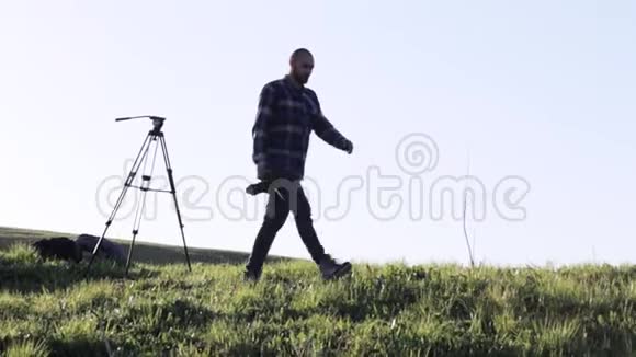 野生动物自然摄影师与三脚架步行在山景视频的预览图