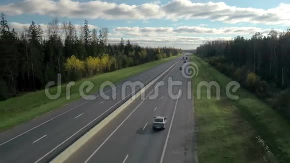 以森林和天空为背景的现代分割公路或道路的空中拍摄远离城市的交通视频的预览图