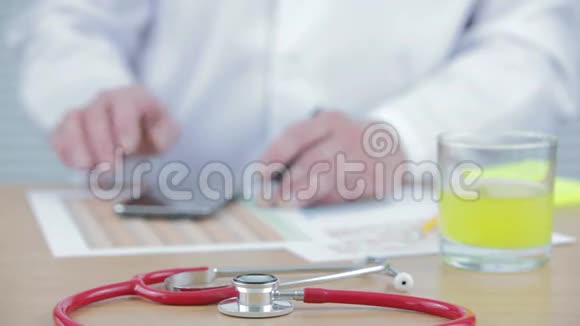 他桌上的医生在打他的智能手机视频的预览图