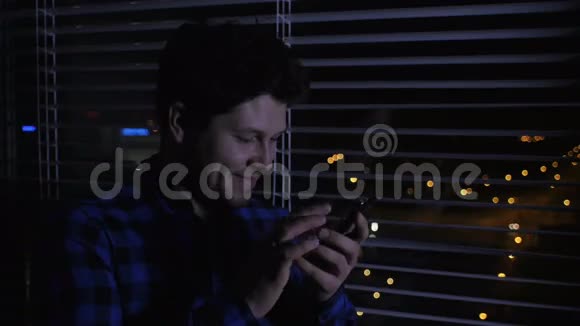 开朗的男人晚上用智能手机视频的预览图