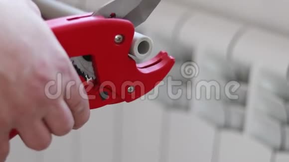 人用红色剪刀剪管取暖或浇水聚丙烯安装系统视频的预览图