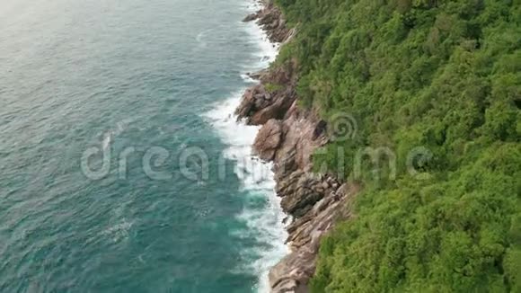 鸟瞰美丽的海浪和岩石海岸的绿色景观视频的预览图
