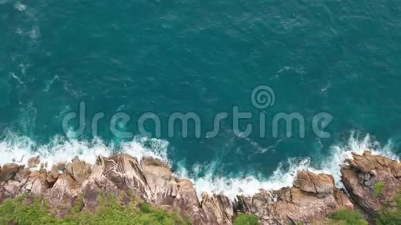 鸟瞰美丽的海浪和岩石海岸的绿色景观视频的预览图