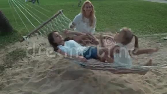 快乐的母亲在吊床上摇着女儿视频的预览图