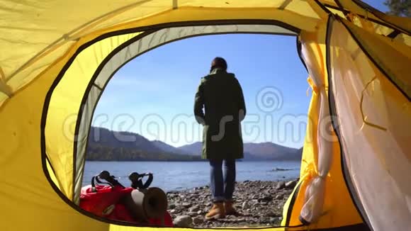 阿尔泰野营的女人躺在帐篷里穿着徒步旅行靴在度假时放松两个视频视频的预览图