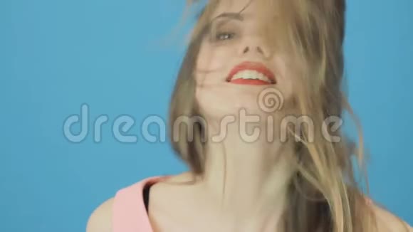 可爱的年轻女子在蓝色的背景上唱歌布鲁内特长发在工作室视频的预览图