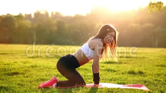 年轻漂亮的女人正在休息时坐在垫子上健身运动后在阳光下休息视频的预览图