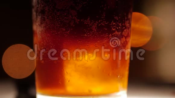加冰的深色鸡尾酒特写镜头在模糊的背景上视频的预览图