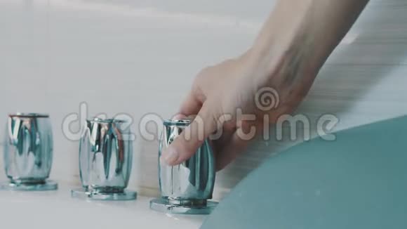 女孩打开金属发光水龙头的浴缸在浴室水卫生视频的预览图