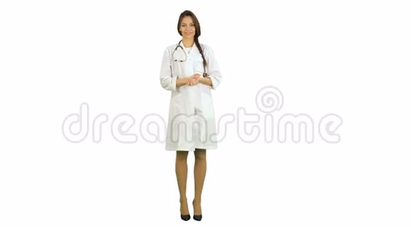 漂亮的年轻女医生穿着实验室外套用听诊器在白色背景下看着摄像机视频的预览图