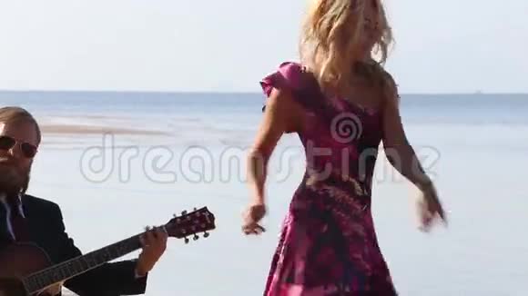 吉他手停止演奏金发女孩停止在海滩上跳舞视频的预览图