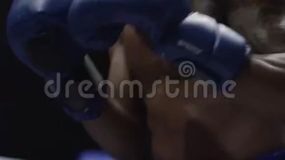 戴拳击手套的人拳击在镜头前特写镜头年轻人冲拳的特写拳击手进行上切视频的预览图