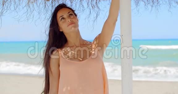 美丽的女士在海滩伞架上视频的预览图